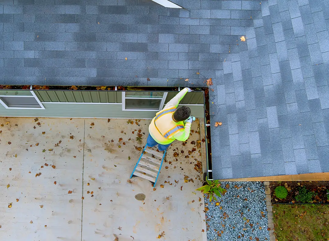 cleaning-clogged-roof-gutter-from-dirt-2