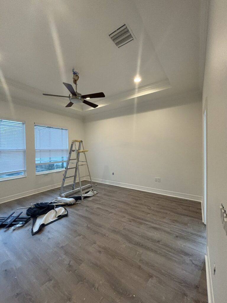 Residential room during painting with a ladder and work materials visible