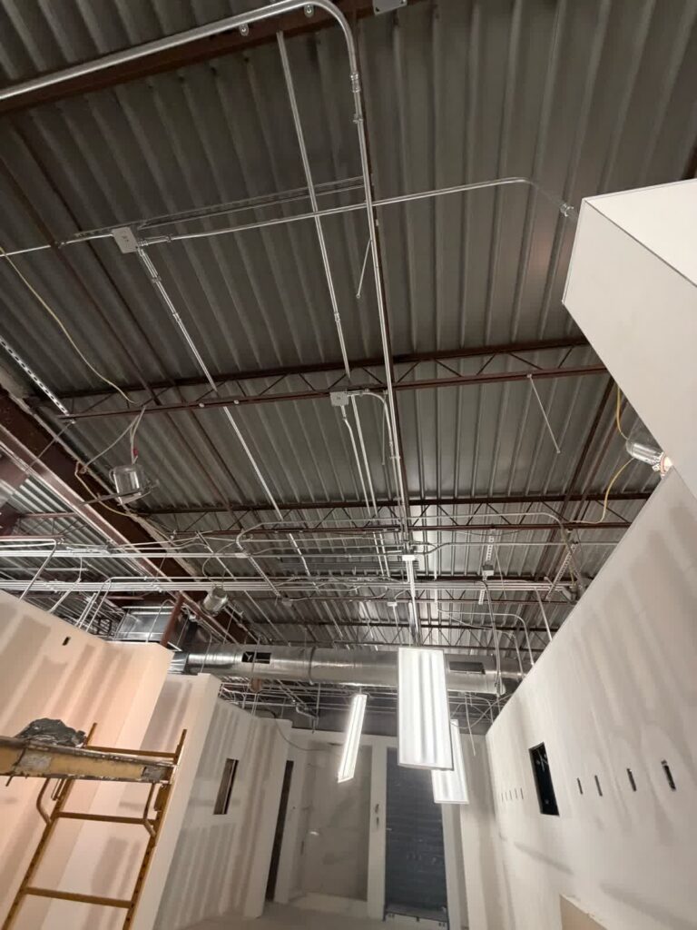 Open-ceiling area during Tampa showroom painting progress