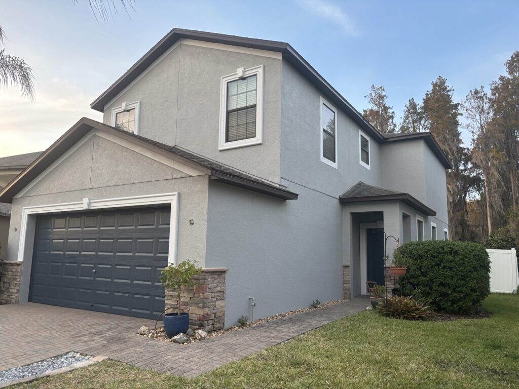 Completed gray two-story exterior repaint with white trim by Purple Painting